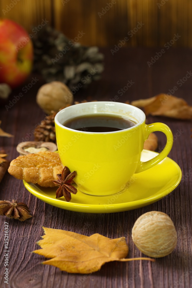 Autumn lifestyle with hot tea, sweets, nuts and yellow leaves