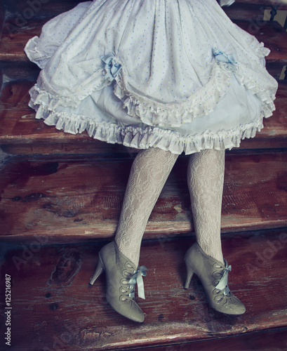 Obraz na płótnie Falda, medias y zapatos de tacón estilo vintage, lolita. Ropa de época sobre escaleras de madera antigua. w salonie