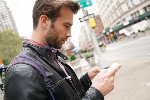 Tourist in New york city looking at city guide on smartphone