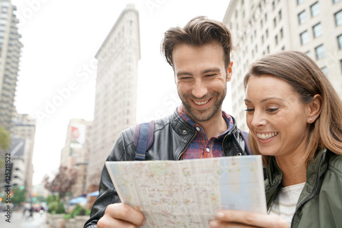 Couple in New york city looking at tourist map by Flatiron