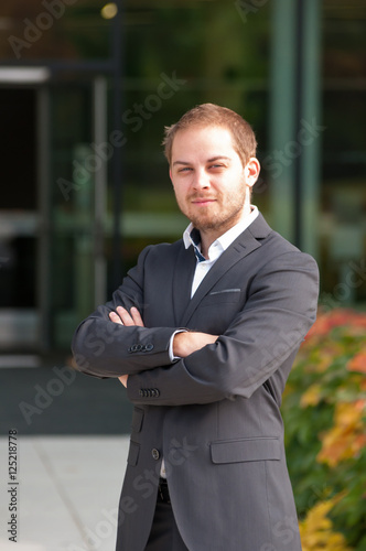 Standing businessman in suit in front of office park. man in suit in front of entrance door