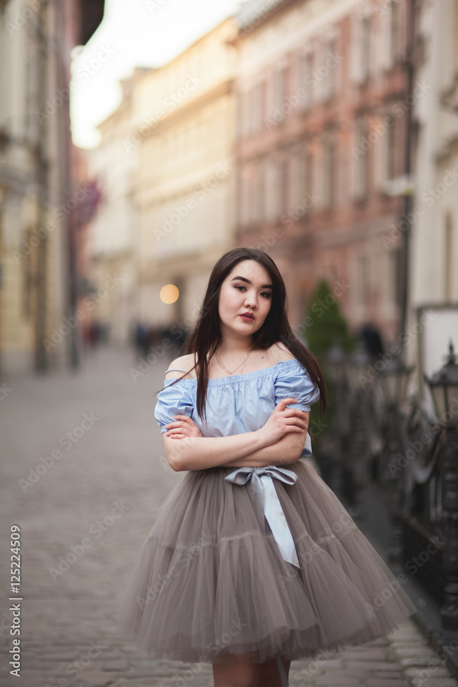 Fototapeta premium Young Asians girl with modern dress posing in an old Krakow