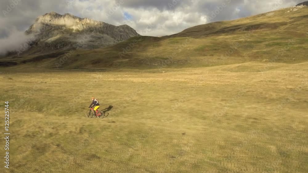 Aerial shot of mountain biker riding a grass covered trail on alpine pass in autumn season
Aerial shot of mountain biker riding a grass covered trail on alpine pass in autumn season