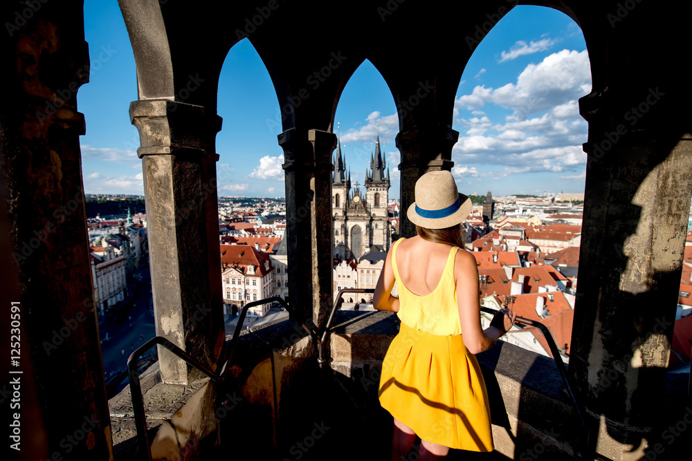Fototapeta premium Young female tourist enjoying great view on the old town of Prague from the top of the clock tower