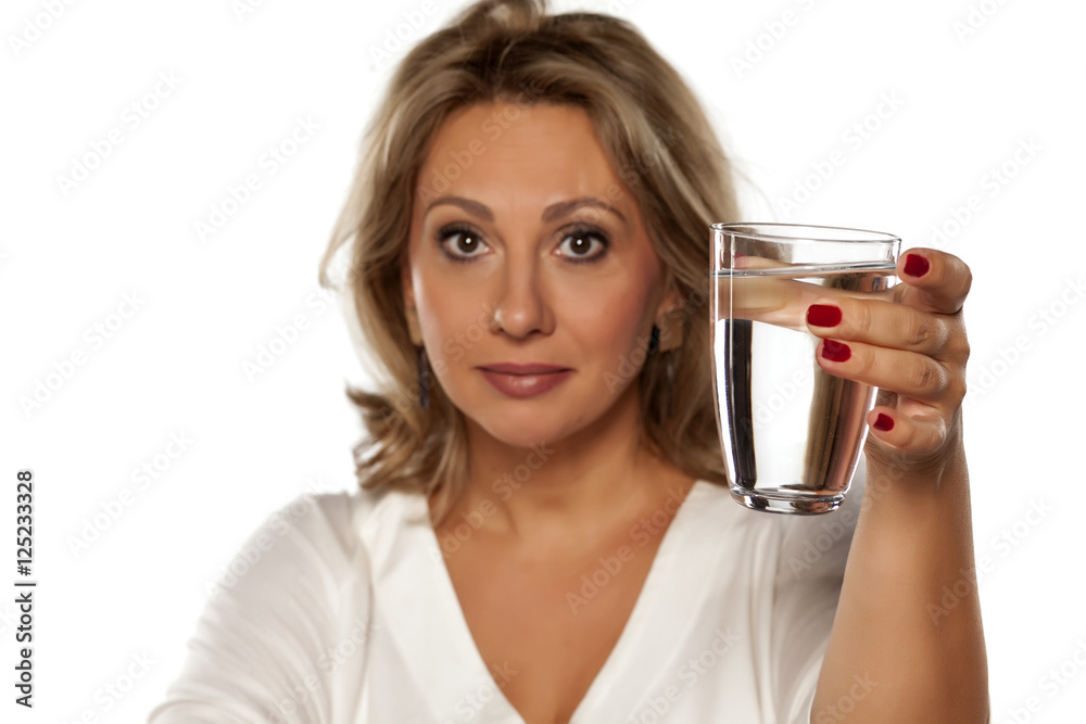 positive middle-aged woman holding a glass with water