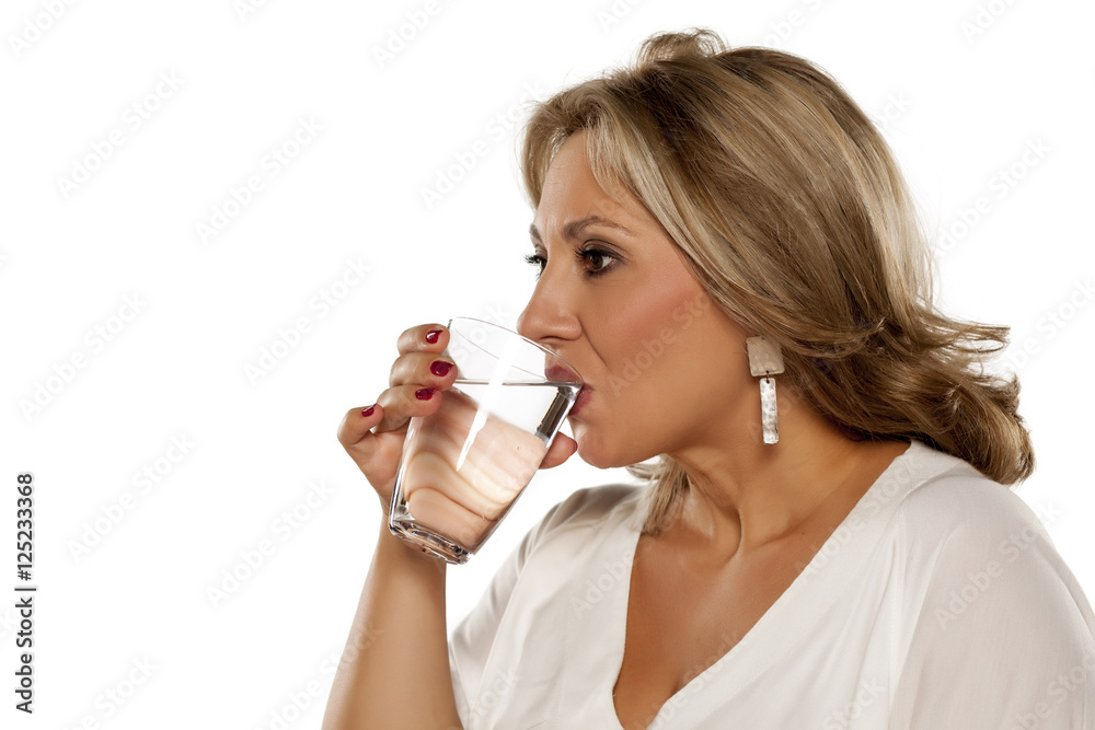 beautiful middle-aged woman drinks water from the glass beautiful middle-aged woman drinks water from the glass