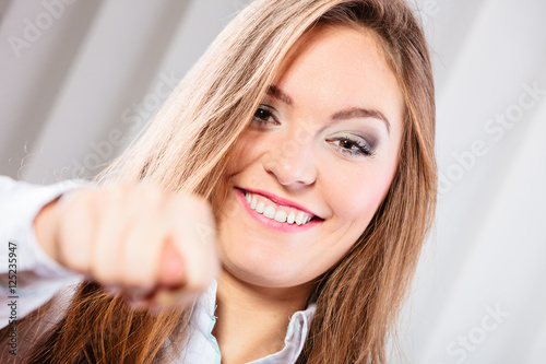 Young woman make silly faces hold fist.