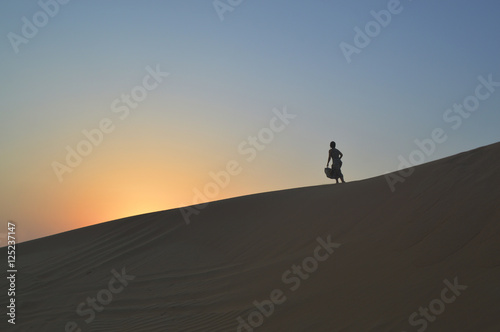 girl in the setting sun in the desert