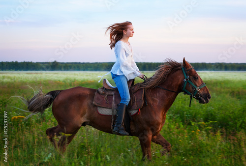Young woman riding bay horse in foggy field