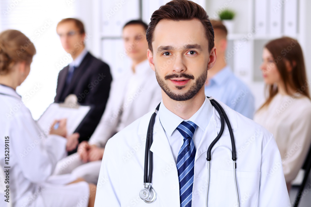 Friendly bearded male doctor with patients Friendly bearded male doctor with patients