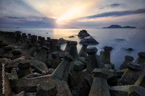 Seascape during sunrise . Concrete block dropped as the waves silly beach at sunrise Beautiful natural summer seascape photo in beach Thailand . Long Exposure seascape photography .