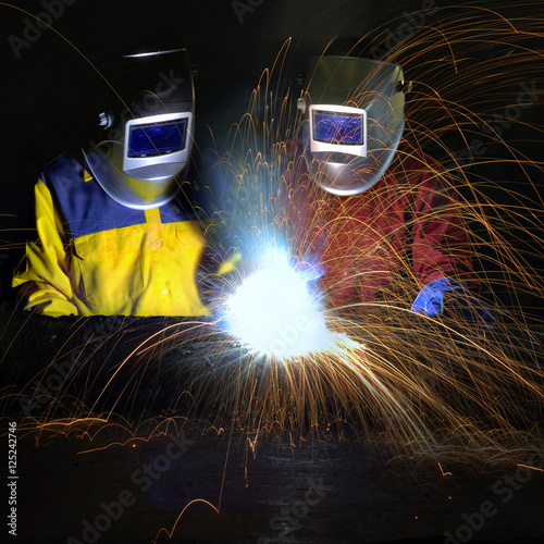 Welder , Industrial worker welding metal with many sharp sparks and worker during use electric wheel grinding 