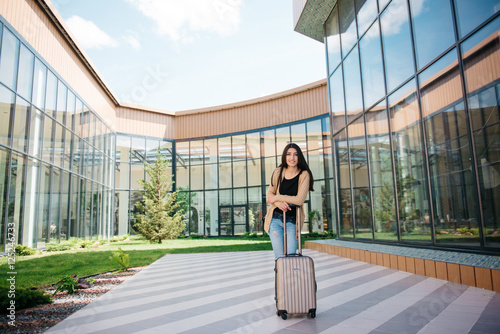 young attractive girl with a suitcase goes on the terminal