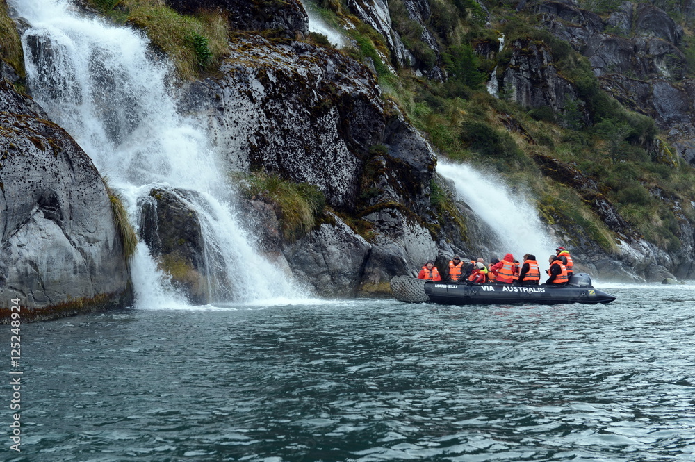 Fototapeta premium Tourists from the cruise ship near the waterfalls of the glacier Nena.