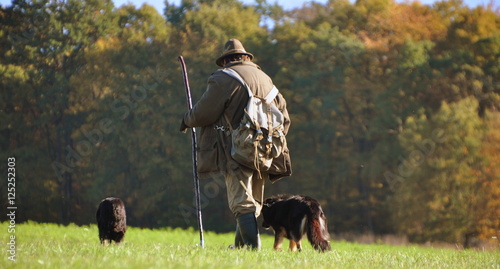 Schäfer mit seinen Hunden in herbstlicher Landschaft photo