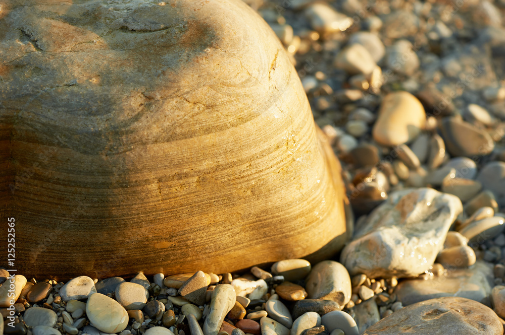 Wet sea stones lying on the beach. Close