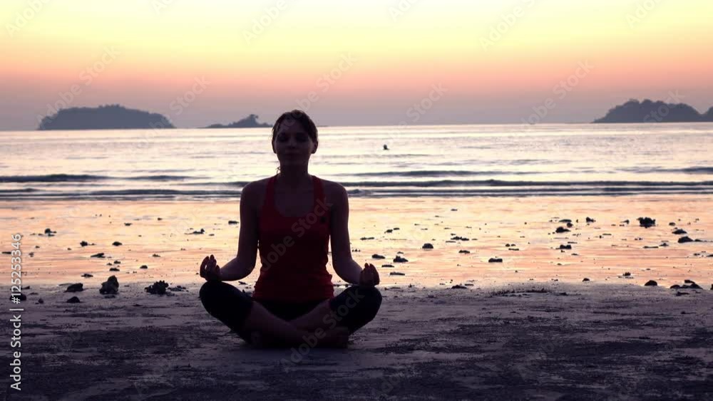 Young woman meditating on beach near sea
Young woman meditating on beach near sea