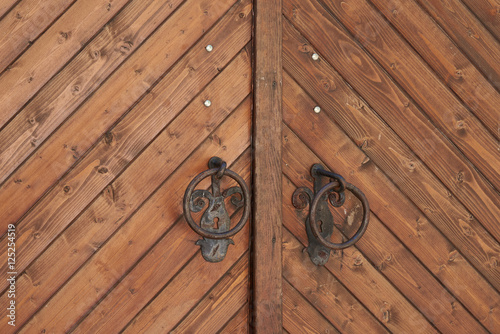 A fragment of a wooden door with metal handles