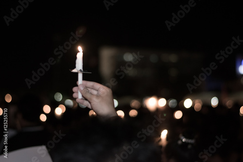 Blurred image for background of hand with candle memorable for King Bhumibol Adulyadej of thailand photo