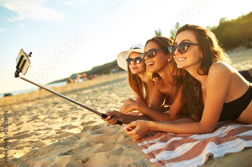 summer holidays and vacation - girls sunbathing on the beach.girls doing selfie phone. enjoy summer time. Fun at the beach. Great summer mood. sunny day