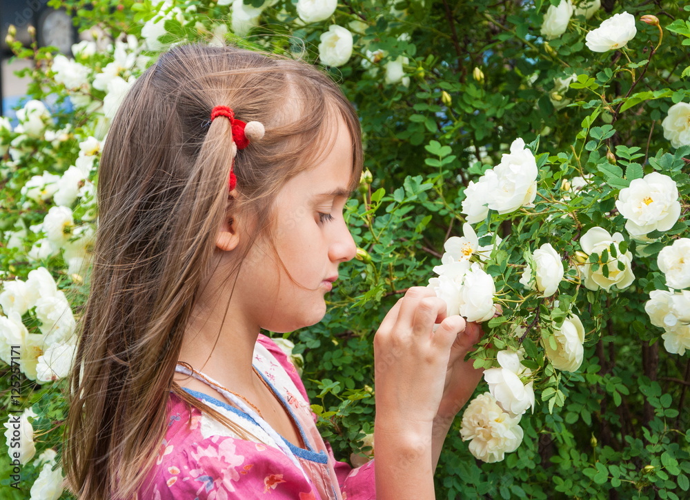 Φωτογραφία Portrait of a sad girl with white roses in the garden