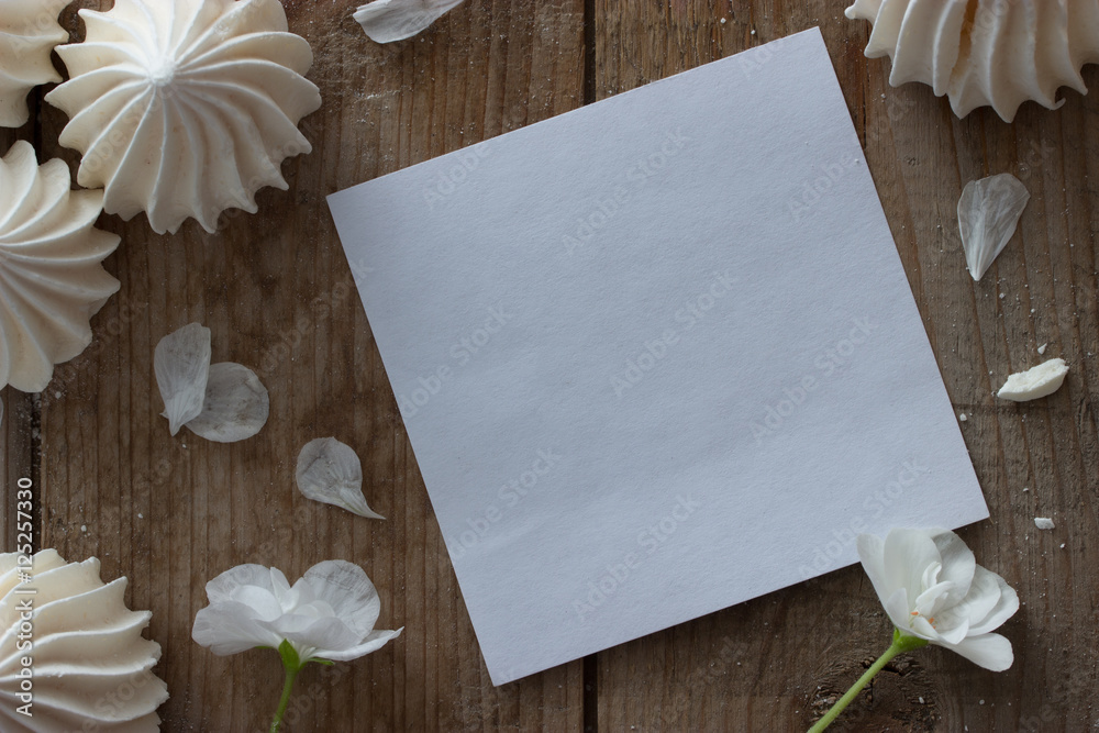 Φωτογραφία white zephyr and piece of paper on wooden table, mock up