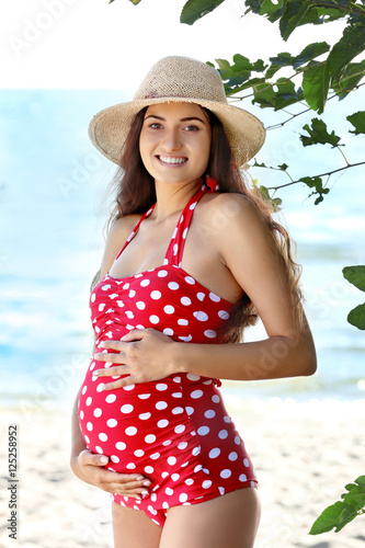 Young pregnant woman in red...