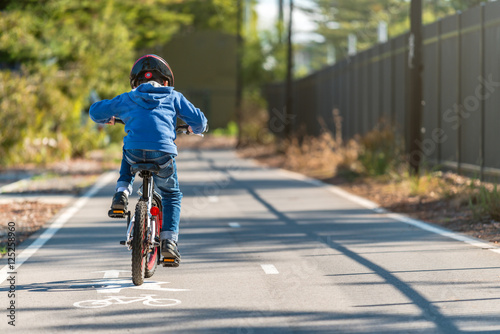 Fototapeta Naklejka Na Ścianę i Meble -  Kid riding his bicycle on bike lane