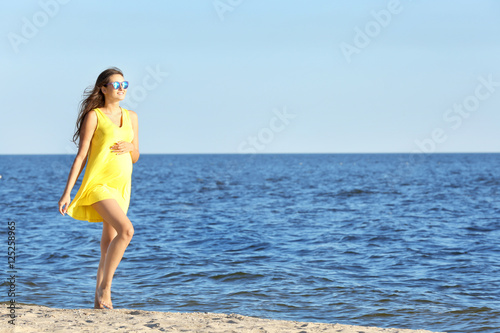 Young pregnant woman in yel...