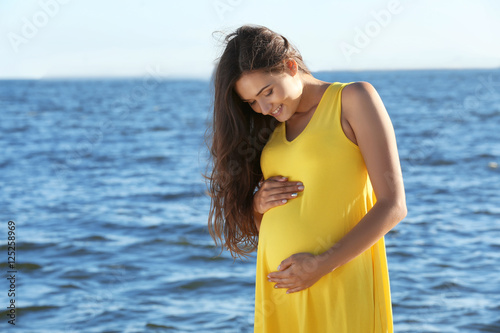 Young pregnant woman in yel...