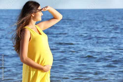 Young pregnant woman in yel...