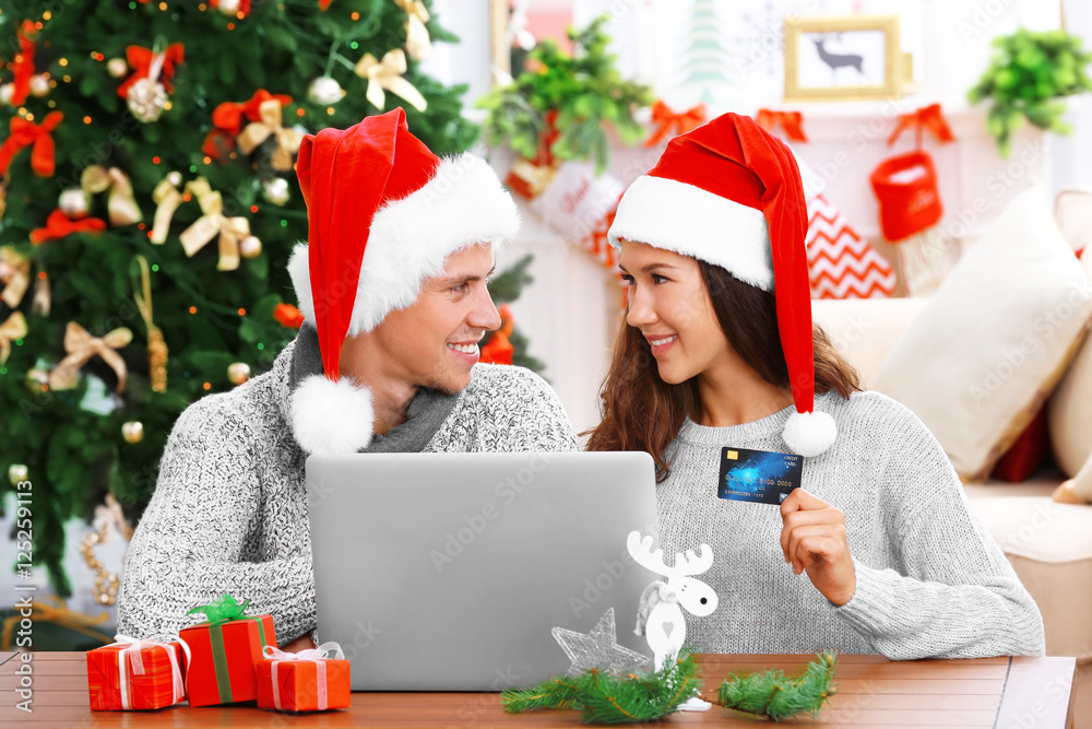 Φωτογραφία Young couple shopping online with credit card at home for Christmas