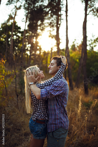 Photography A young couple kiss in park at sunrise