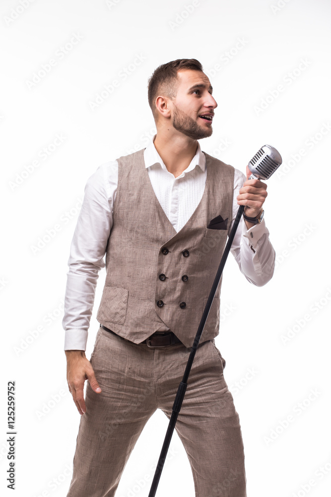 Naklejka premium Young man in suit singing over the microphone with energy. Isolated on white background. Singer concept.