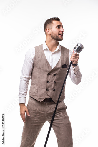 Young man in suit singing over the microphone with energy. Isolated on white background. Singer concept.