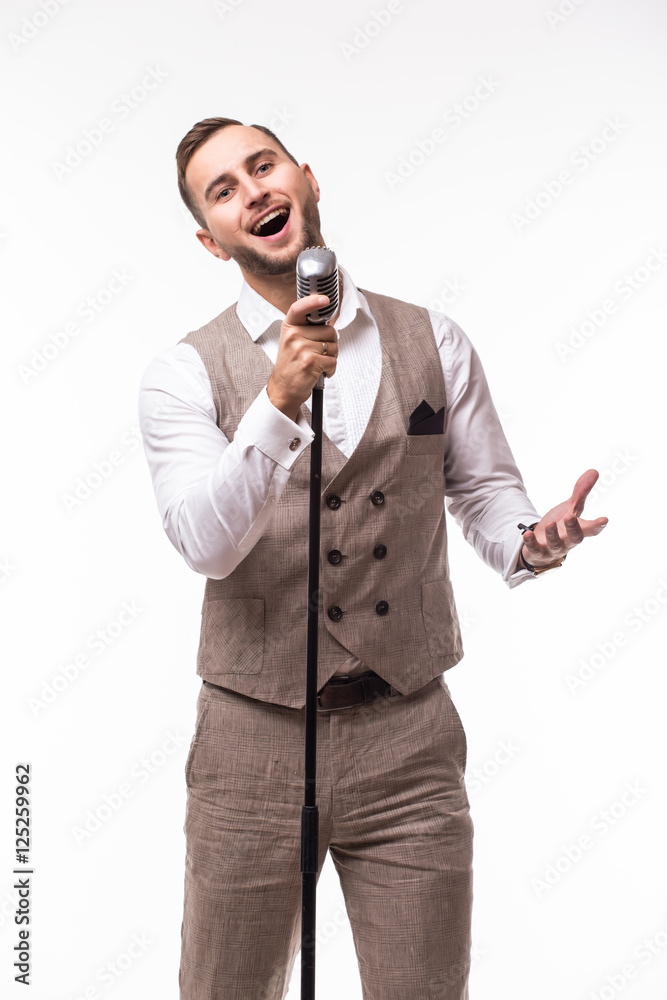 Naklejka premium Young man in suit singing over the microphone with energy. Isolated on white background. Singer concept.