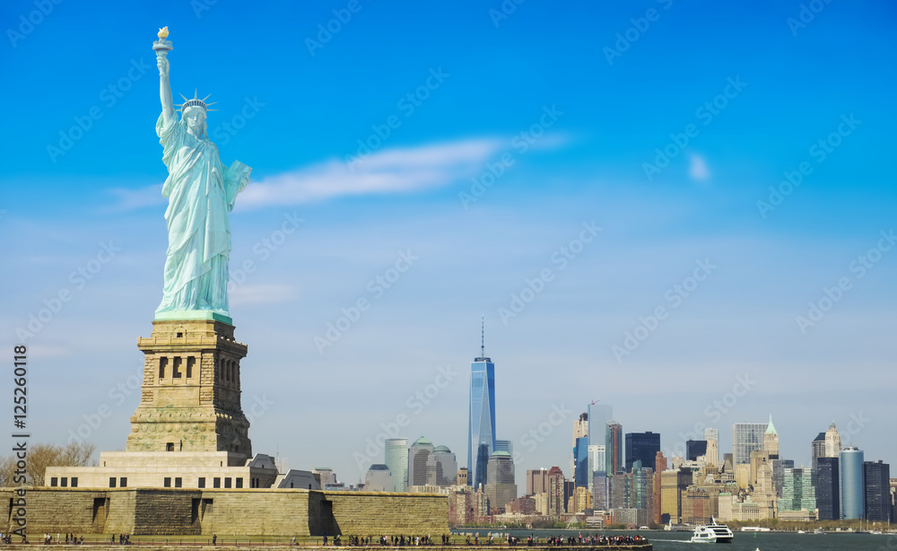 Obraz premium Statue of Liberty on a sunny day, Manhattan in the background. This is a photo-montage, because the statue faces to the viewer