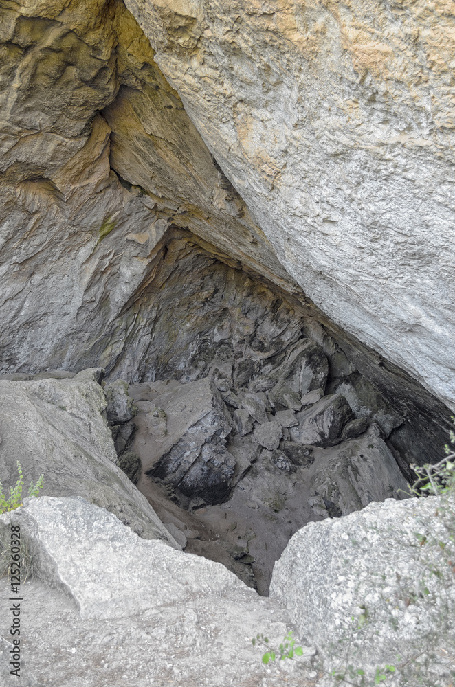Naklejka premium The black cave. Old and primitive shelter formed over the bedrock of mountain. It's located in Montanejos, inside the region of Castellon (Spain)