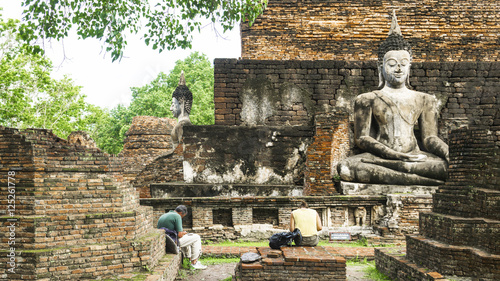 The ruin of the Thai temple  in historical Park with people are sit in the architecture.