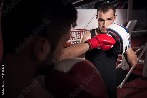 Young trainer holding boxing pad
