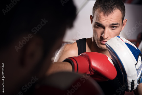 Young trainer holding boxing pad © Viacheslav Yakobchuk