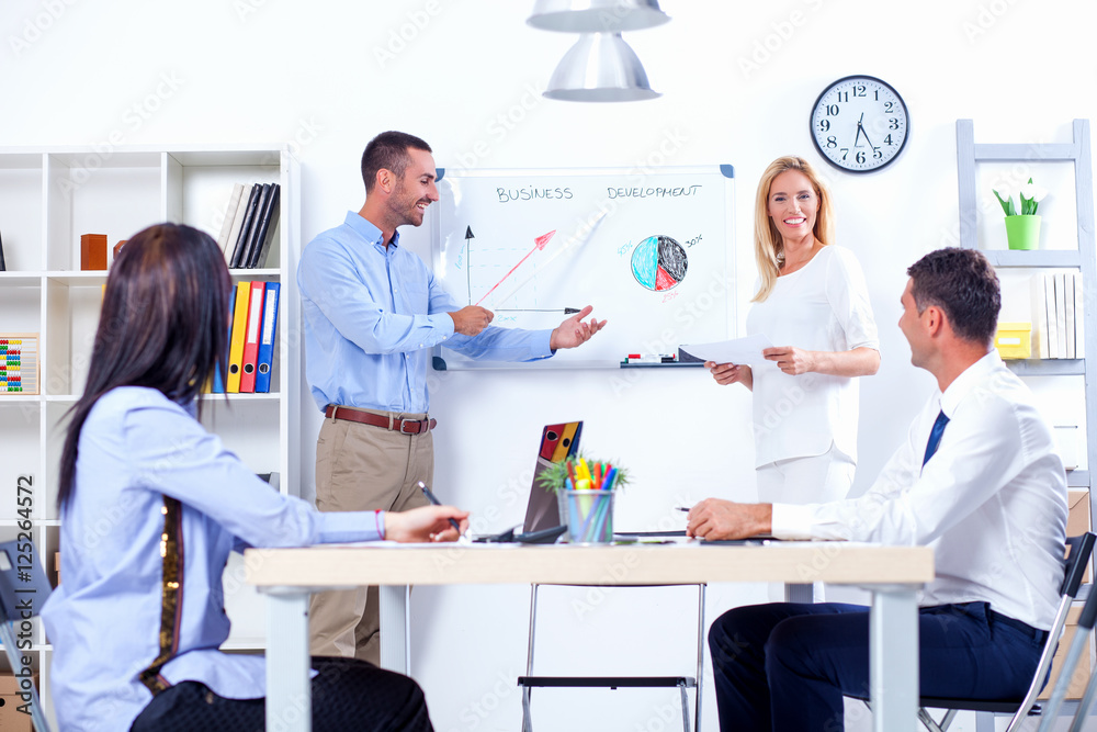 Obraz premium Group Of Business People Having Meeting In Office. Business partners discussing documents and ideas at meeting