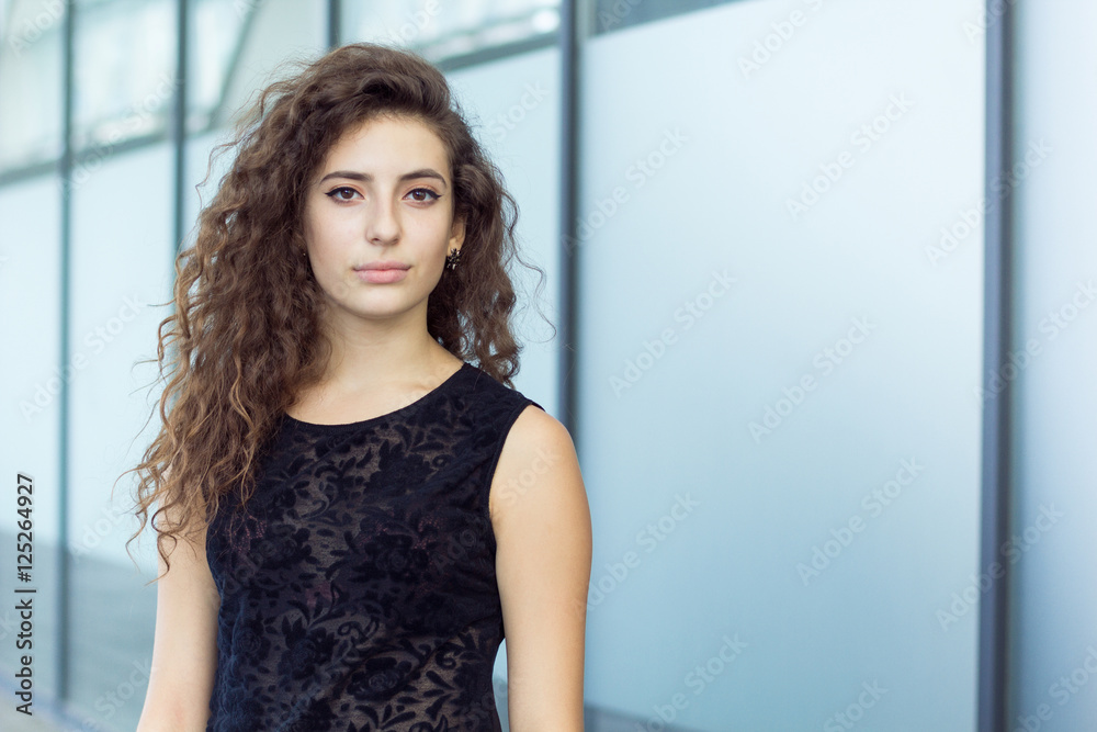 Indifferent gaze curly girl, portrait outdoors