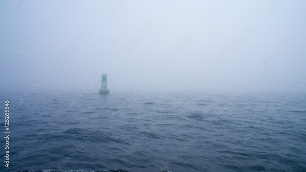 Green channel marker buoy in the fog