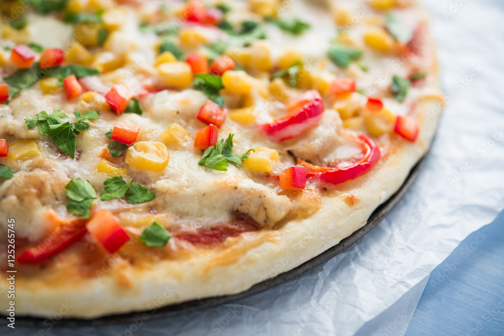 Pizza with mozzarella cheese, chicken, sweet corn, sweet pepper and parsley. Italian cuisine.