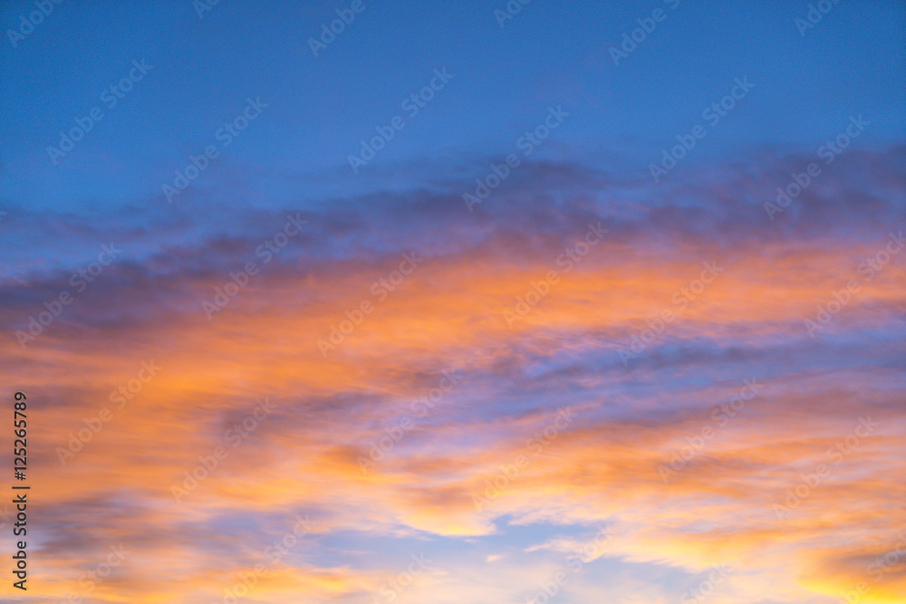 Dramatic sunset sky with orange colored clouds in summer season.