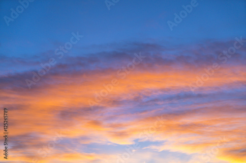 Dramatic sunset sky with orange colored clouds in summer season. © checubus