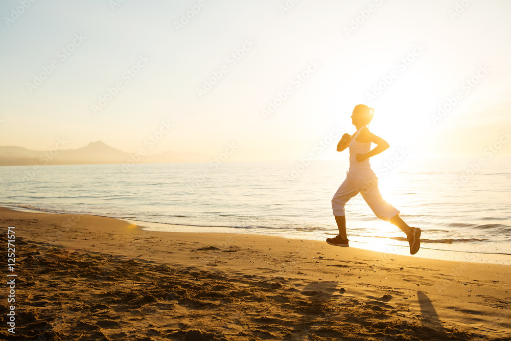 Fototapeta premium Caucasian woman jogging at seashore