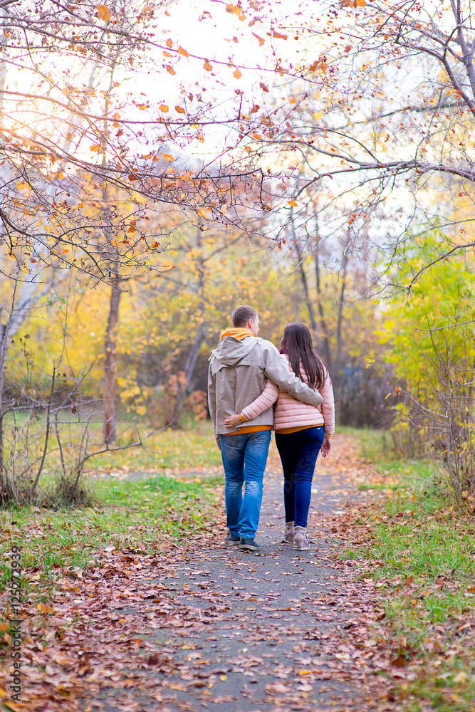 smiling couple hugging in autumn park from back smiling couple hugging in autumn park from back