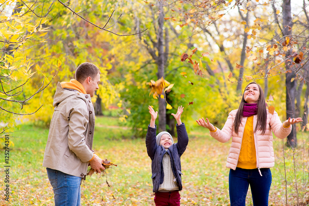 Fototapeta premium family playing with leaves autumn park